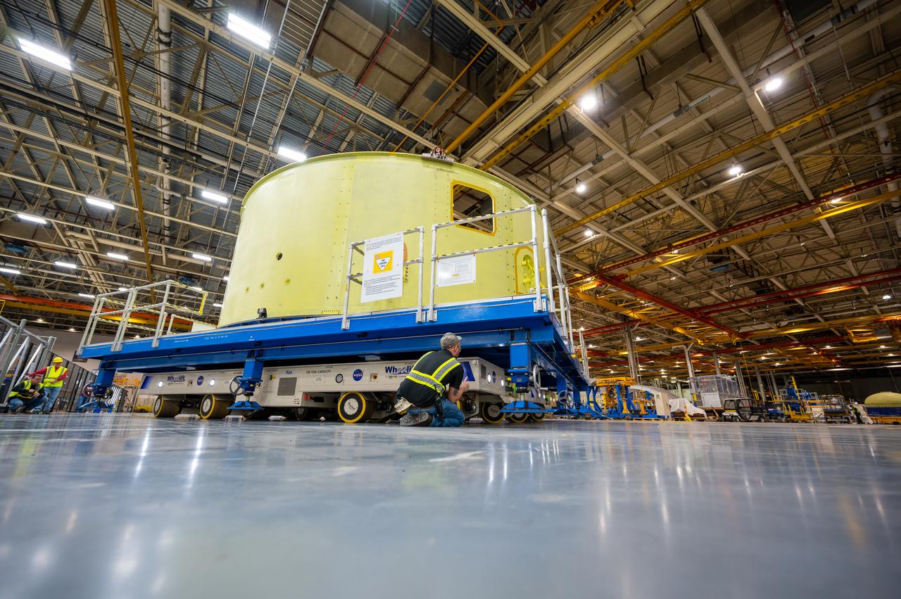Crews at NASA’s Michoud Assembly Facility in New Orleans move the forward skirt of NASA’s Space Launch System (SLS) rocket to another part of the facility Dec. 15. Teams are preparing to apply the thermal protection system to the flight hardware, which will protect it from the extreme temperatures during launch and flight. The forward skirt is part of the core stage that will power the SLS rocket for the Artemis III mission. The forward skirt houses flight computers, cameras, and avionics.. The SLS core stage is made up of five unique elements: the forward skirt, liquid oxygen tank, intertank, liquid hydrogen tank, and the engine section. When fully stacked, the forward skirt is located at the top of the core stage and connects the stage to the upper part of the rocket. Together with its four RS-25 engines, the rocket’s massive 212-foot-tall core stage — the largest stage NASA has ever built — and its twin solid rocket boosters produce 8.8 million pounds of thrust to send NASA’s Orion spacecraft, astronauts and supplies beyond Earth’s orbit to the Moon and, ultimately, Mars. Offering more payload mass, volume capability and energy to speed missions through space, the SLS rocket, along with NASA’s Gateway in lunar orbit, the Human Landing System, and Orion spacecraft, is part of NASA’s backbone for deep space exploration and the Artemis lunar program. No other rocket is capable of carrying astronauts in Orion around the Moon in a single mission.